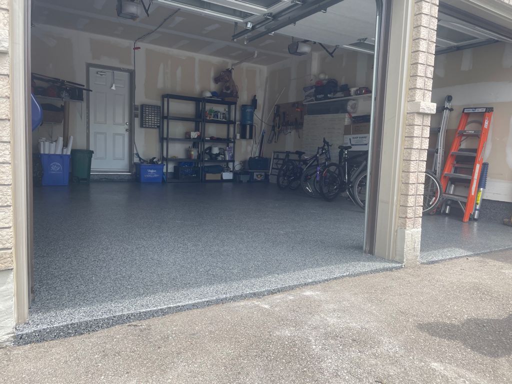 Image depicts a garage from our epoxy 2-car garage Mpale project, showing a garage with new epoxy flooring.