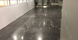 Image depicts a basement floor in a Woodbridge home with black stain and high gloss.