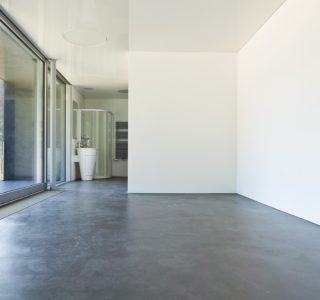 Image depicts a modern hotel room with recently polished concrete floors.